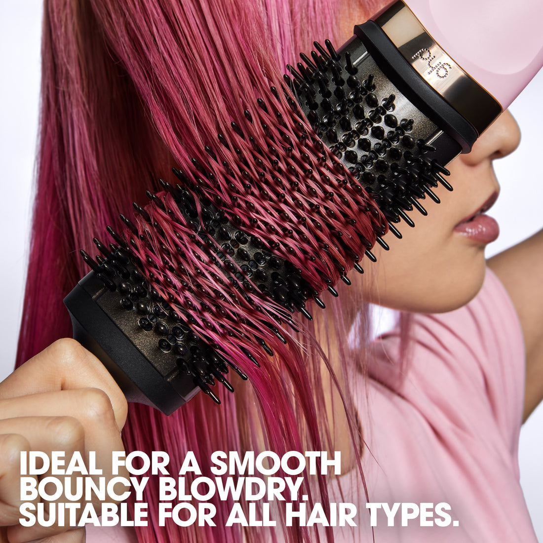 Person using a hair dryer with a brush attachment on pink hair, with text about hair care.