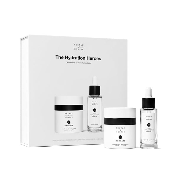 A skincare set from Pure Encapsulations called 'The Hydration Heroes', featuring a white gift box and three individual products: a jar, a dropper bottle, and a serum bottle, all in white and black packaging with clear liquid.
