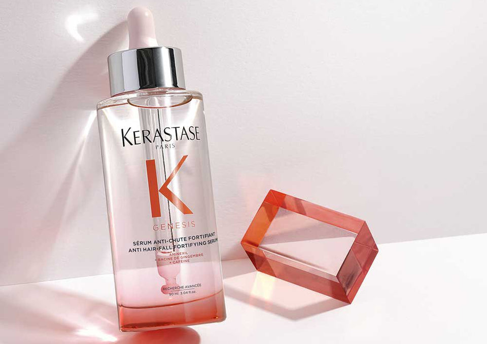 Kerastase serum bottle with a pink gradient on a soft pink background