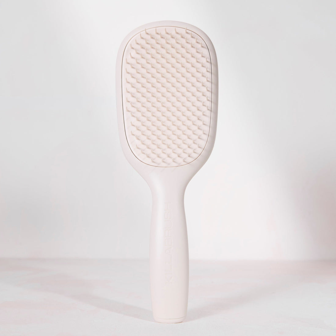 White paddle brush on a light gray background
