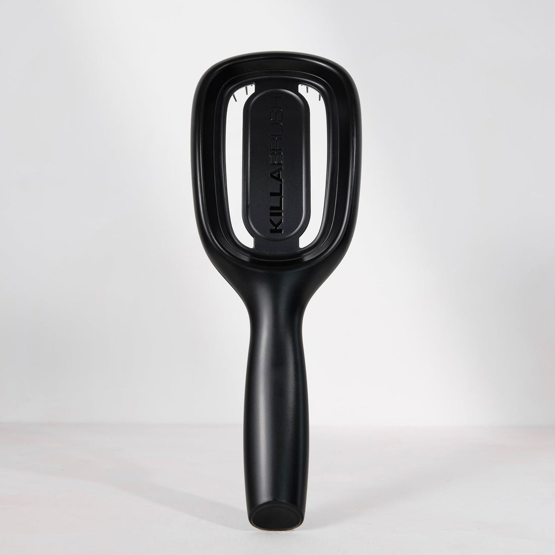 Black hairbrush with 'Killa' branding on a light gray background