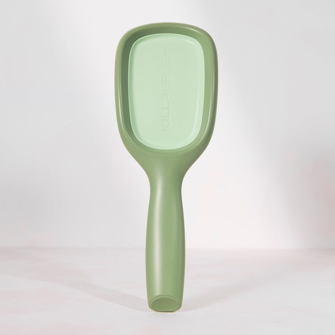 Green paddle brush on a white background