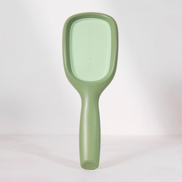Green paddle brush on a white background
