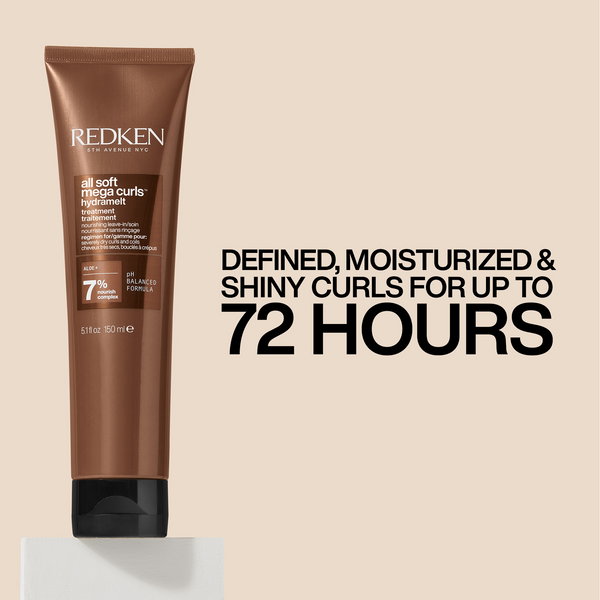 A tube of Redken All Soft Melange Curls Hair Smoother in a warm brown shade, displayed on a light beige background with promotional text that reads 'DEFINED, MOISTURIZED & SHINY CURLS FOR UP TO 72 HOURS'.