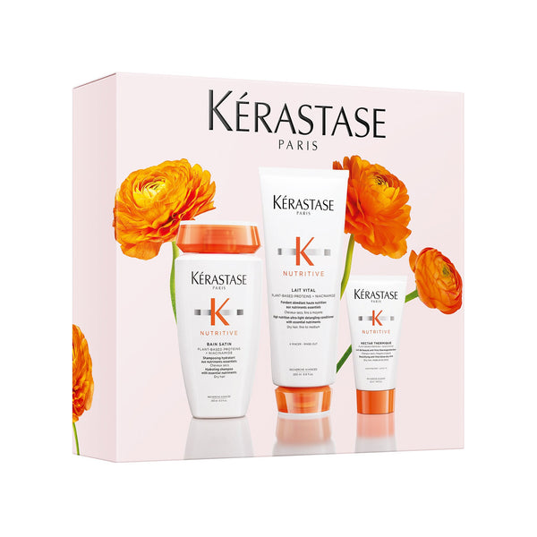 Kérastase hair care products with flowers on a white background