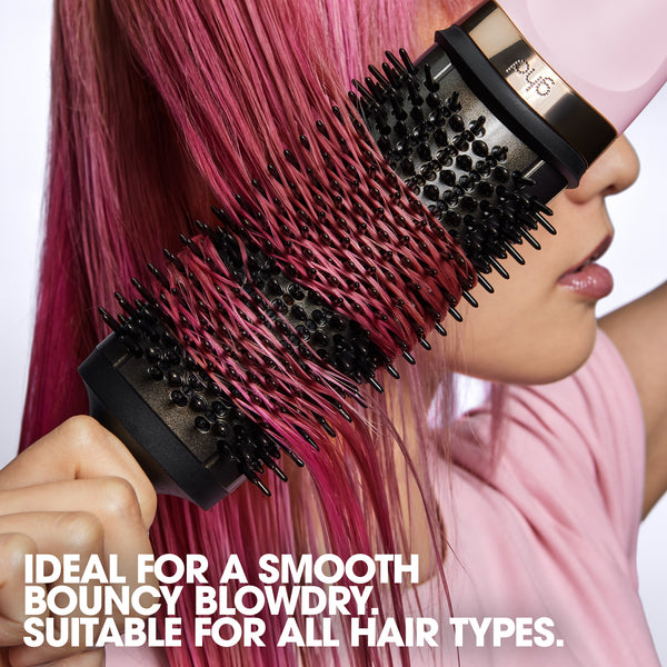 Person using a hair dryer with a brush attachment on pink hair, with text about hair care.