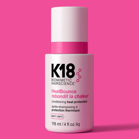 K18 hair product bottle on a pink background
